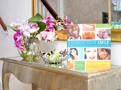 Console table with pink orchids and smile makeover brochures in the Dental Studio entrance