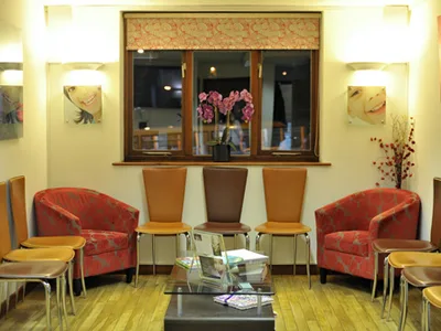 Waiting room with red armchairs and orchids on the window sill
